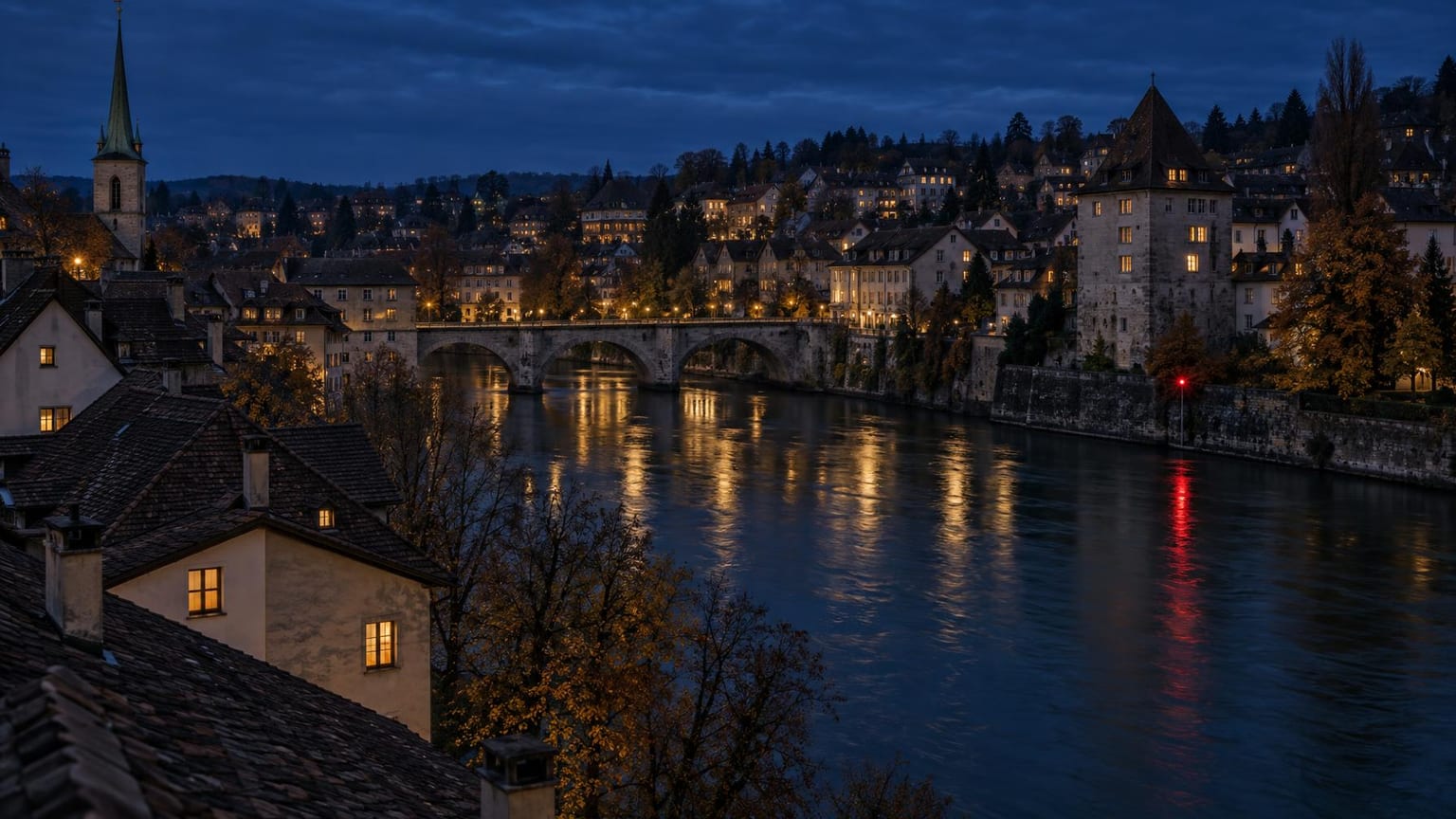 Schweizer Altstadt am Fluss zur blauen Stunde, erleuchtete Fenster und ein einzelnes rotes Signallicht